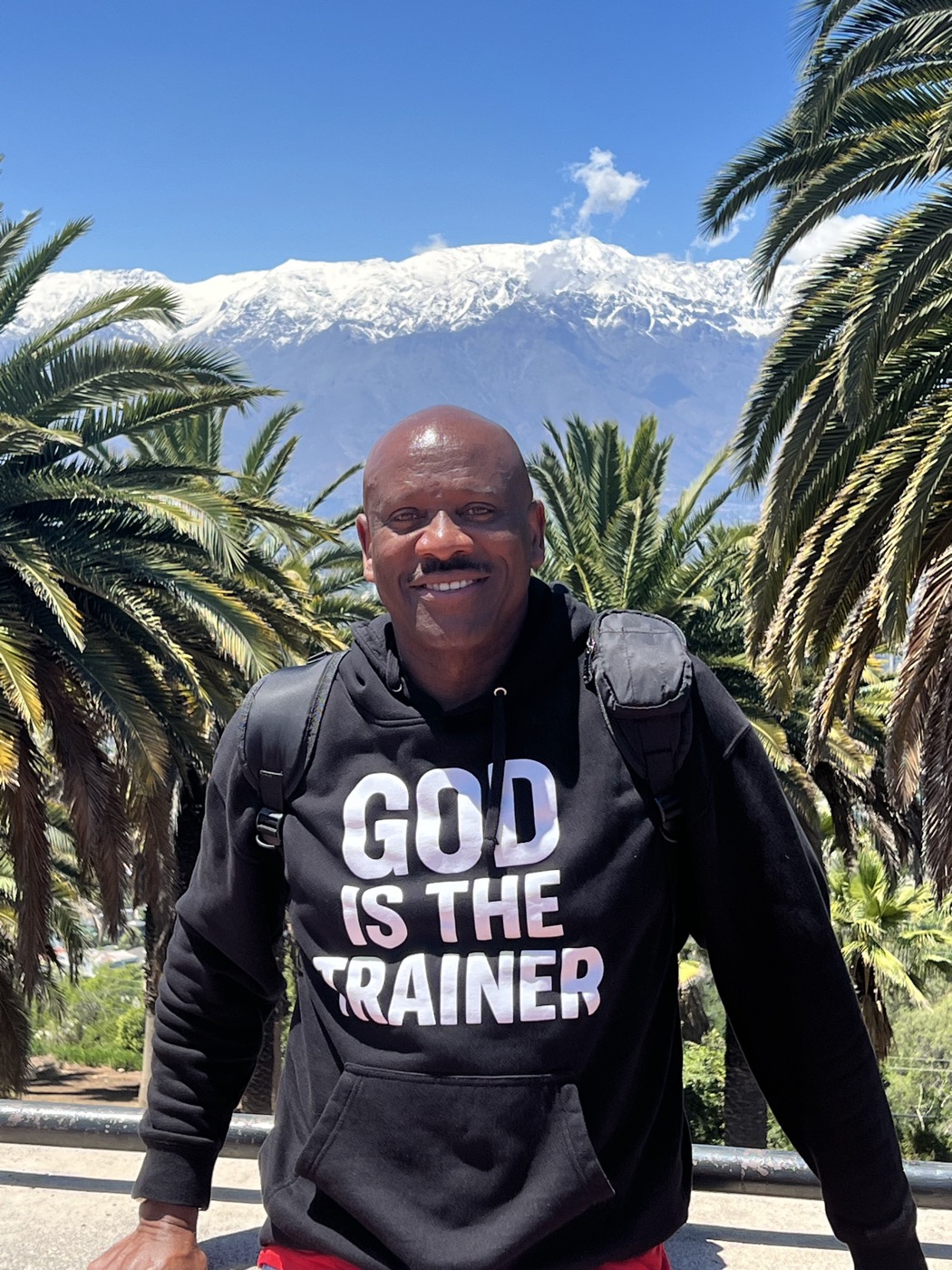 Mr. Tycoon in front of snow-capped mountains